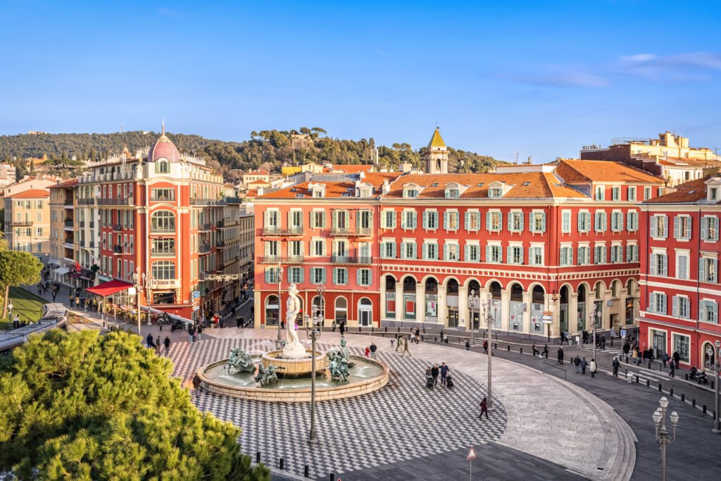Mediterranean Radiance of Place Masséna The photo showcases the colorful architecture and lively atmosphere of Place Masséna in Nice, a central crossroads for festivals and everyday life, framed by period buildings and open avenues.