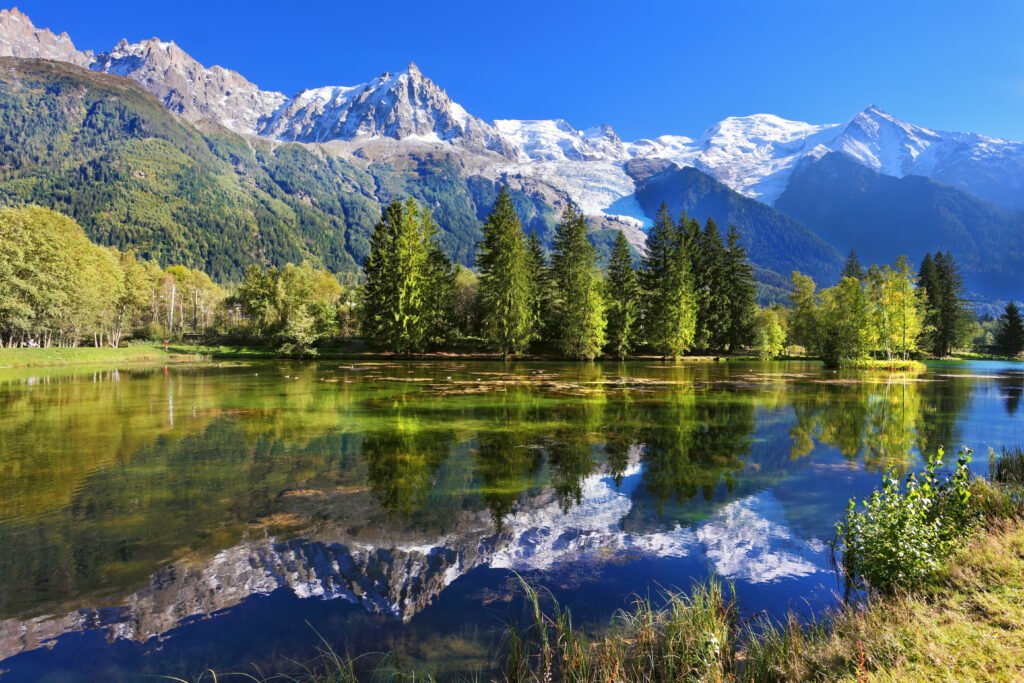 Reflective Beauty of the Alpine Waters This breathtaking scene showcases the peaceful harmony of nature with crystal clear waters reflecting the grandeur of the snow-capped Alps, inviting onlookers to pause and bask in the serene beauty.
