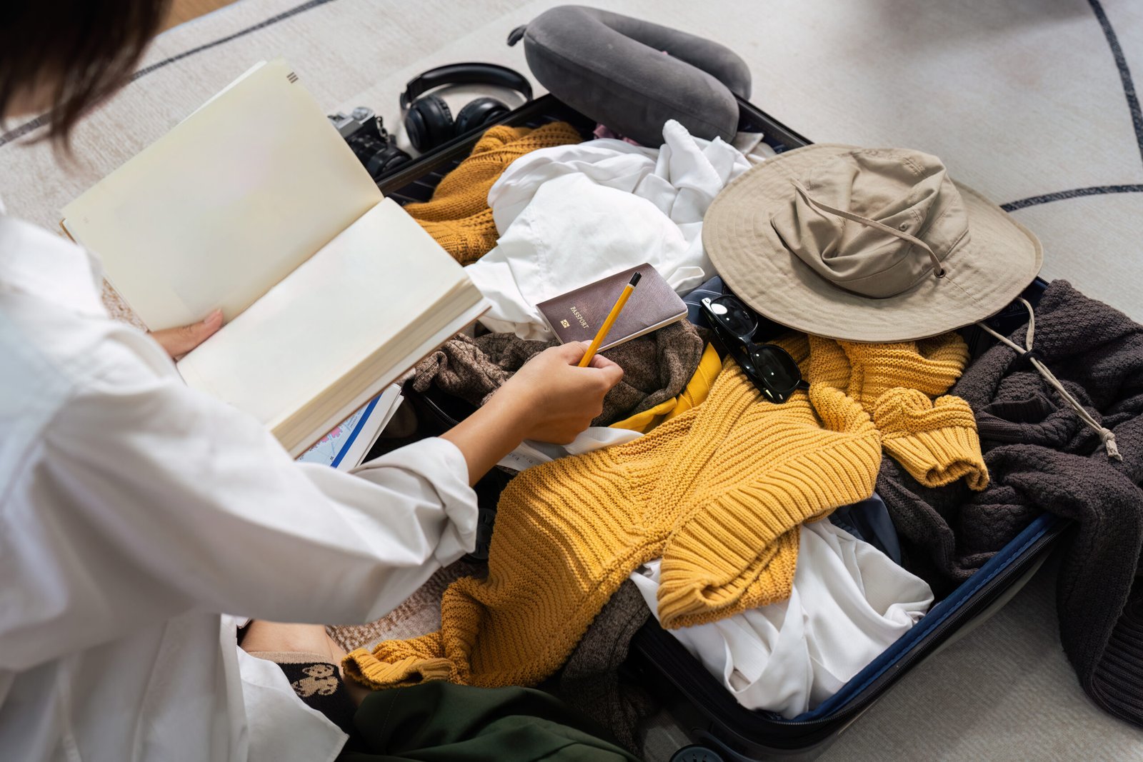 Capturing the anticipation of exploration, here we see the essential items for a traveler's excursion neatly laid out. The process of preparation is as much a part of the journey as the travel itself, shown by the careful selection of apparel, writing materials for journaling, and the crucial passport for international adventures. It conveys the careful planning behind the spontaneous spirit of travel.