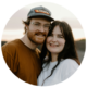 This endearing image showcases a couple encapsulated in a moment of affection as the day winds down. Their smiles, gentle and genuine, reflect a deep sense of comfort and happiness in each other's company. The man's casual baseball cap and the woman's simplistic style suggest a laid-back approach to life, while the soft, dusky light hints at the romance of a sunset backdrop.